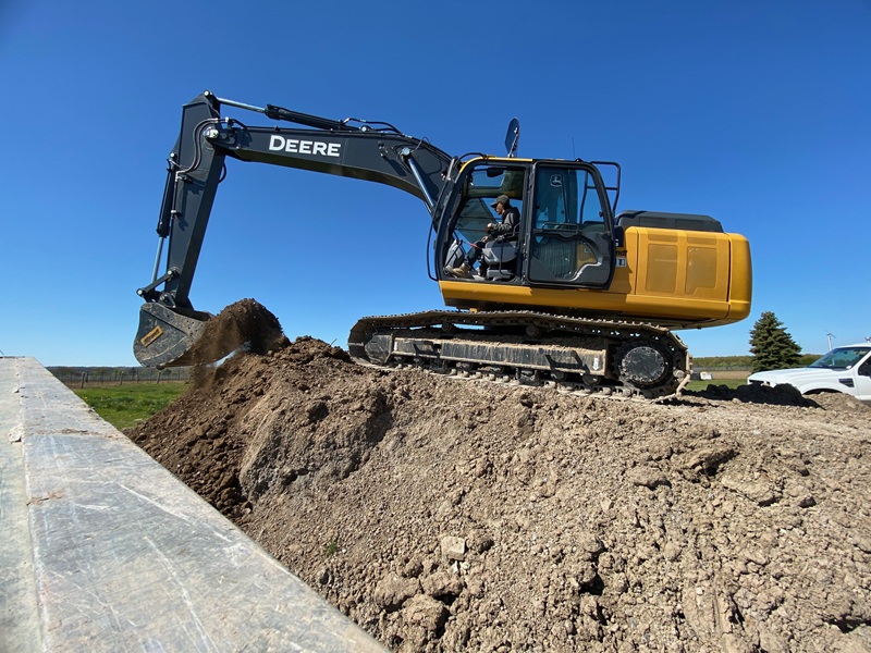 Tracked excavator moving earth during site preparation